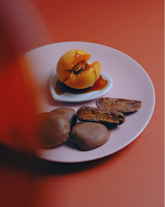 Čokoladne kajsije prelivene mlečnom čokoladom na tanjiru, desert Valentina i Karanfil