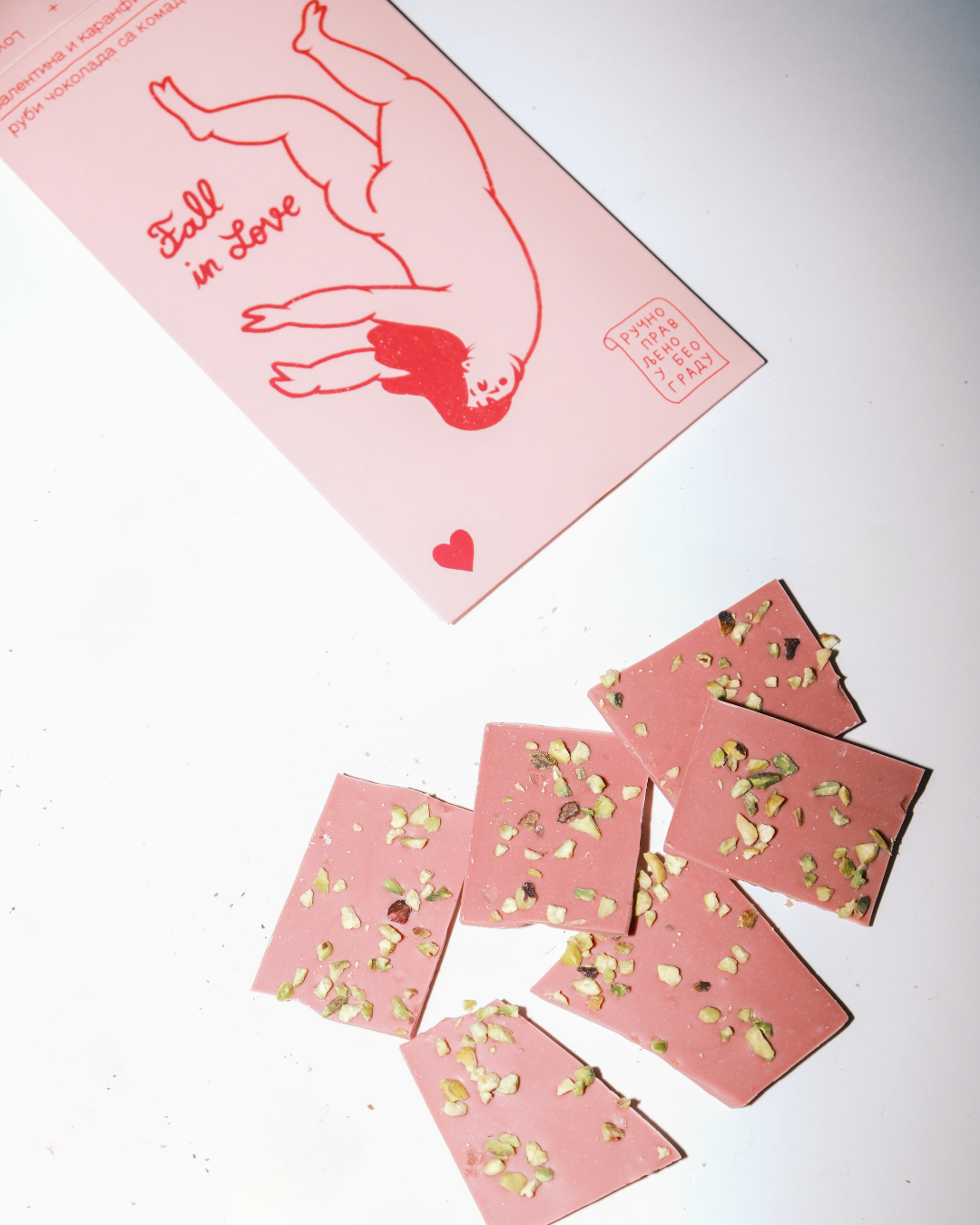 Rubi čokolada sa komadićima pistaća – čokolada Valentina i Karanfil × Lovers.rs, pakovanje u ružičastim tonovima sa ilustracijom figure i natpisom Fall in Love.