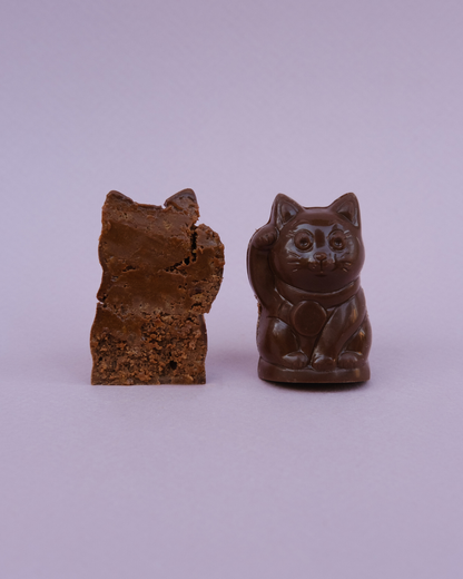 Lucky Cat pralina – cela i presek; vidljiva kremasta punjenja od pekan paste i sloj hrskavog francuskog keksa.