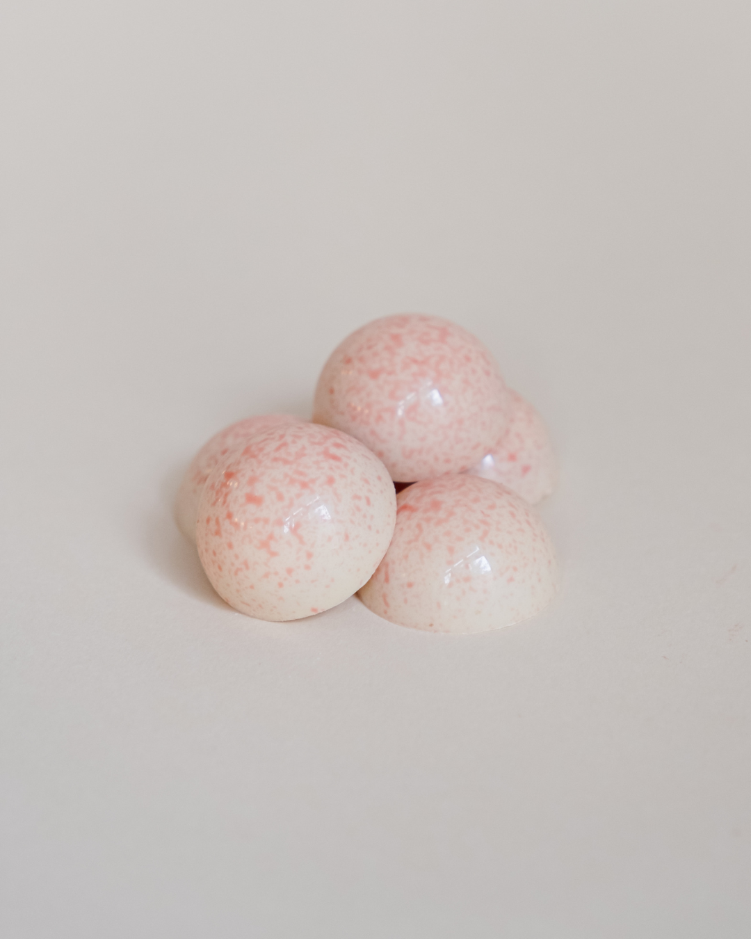 Presek praline: sloj kokosa preko voćnog punjenja od jagode u ljusci od bele čokolade