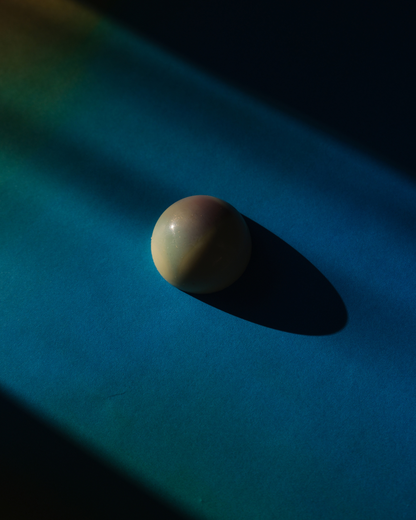 Pralina od bele čokolade sa lavandom i zovom na plavoj pozadini