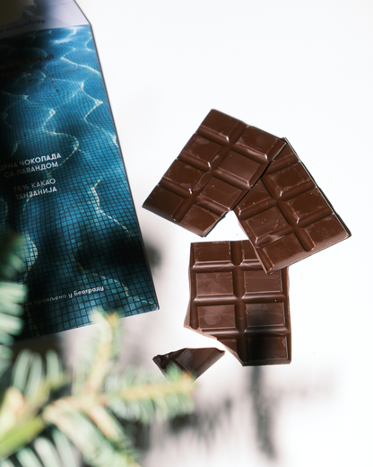 Tabla crne čokolade sa lavandom pored pakovanja Valentina i Karanfil na beloj podlozi, sa senkama grančica.