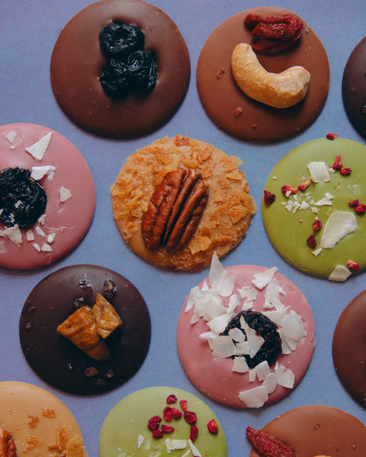 Čokoladni medaljoni od crne, mlečne, rubi i bele karamelizovane čokolade, ukrašeni sušenim voćem i orašastim plodovima, ručno rađeni u Beogradu.
